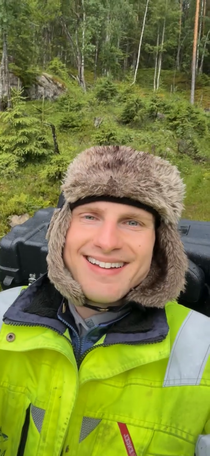 Stanislav smiling in a fur hat and bright jacket in the Norwegian woods