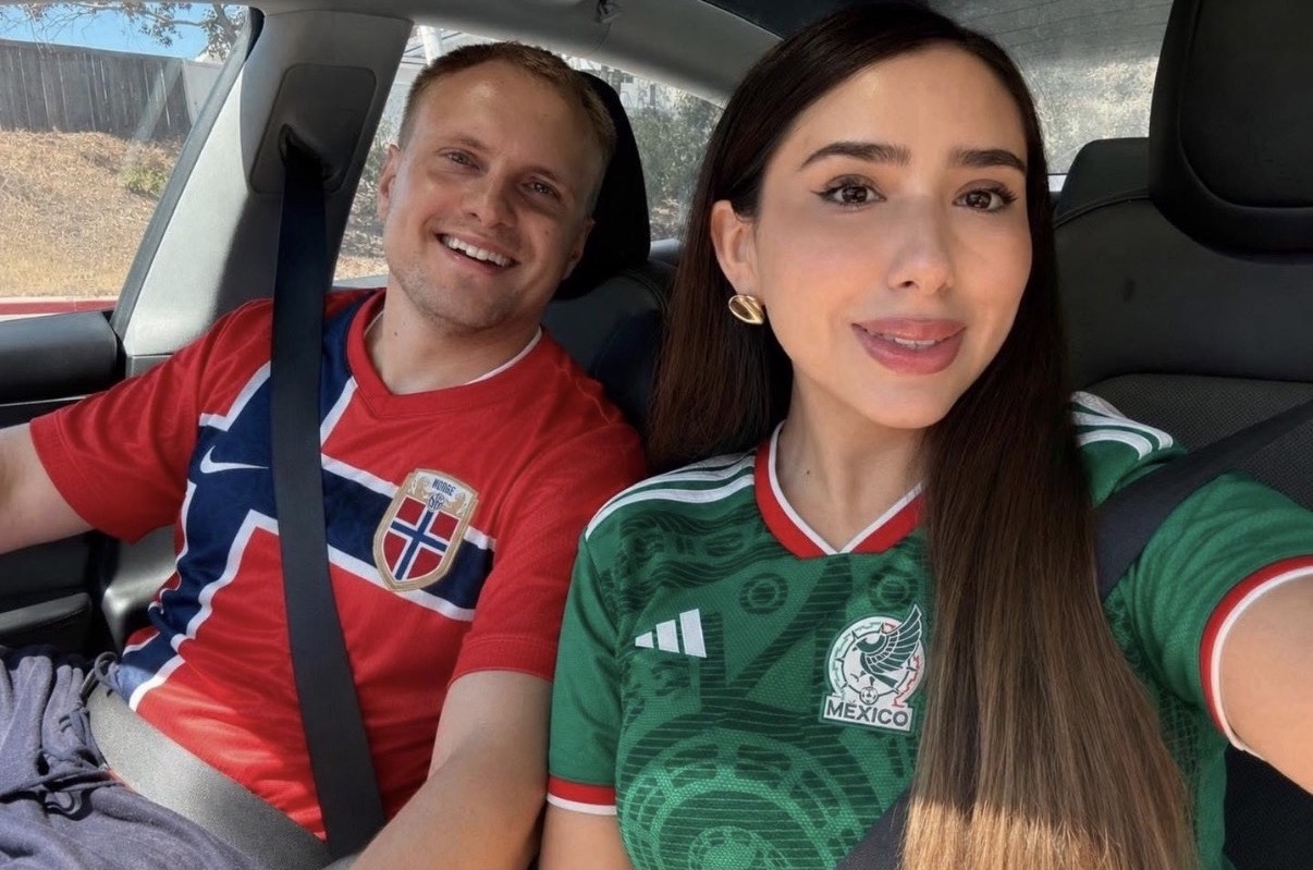 Stanislav and his wife smiling in Norway and Mexico football shirts
